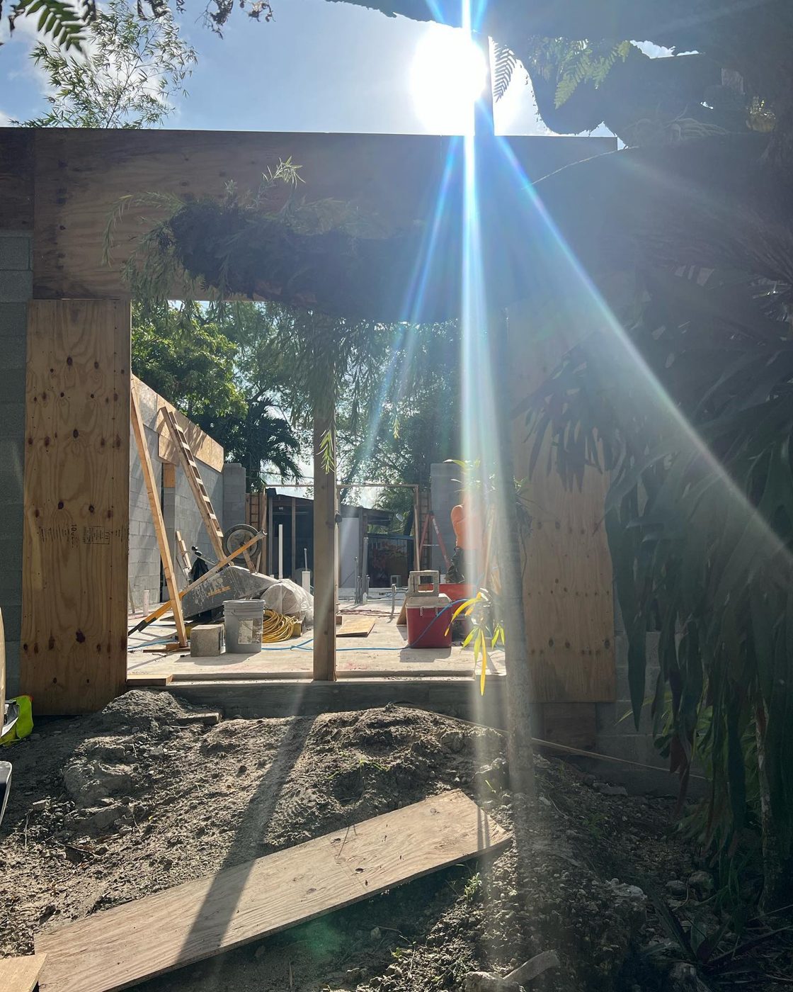 Timber framing on a South Florida build with sunlight streaming through